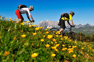 Mountainbiker auf Wiese mit Kaisergebirge im Hintergrund, Ferienwohnung Reit im Winkl